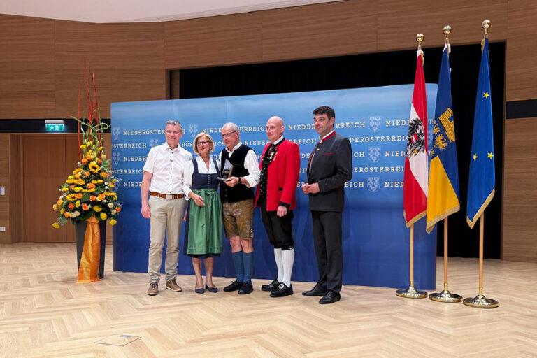 mehrer Personen bei der Verleihung eines Preises in einem Saal