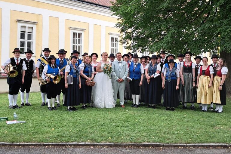 Viele Musiker und Musikerinnen und im Vordergrund das Brautpaar