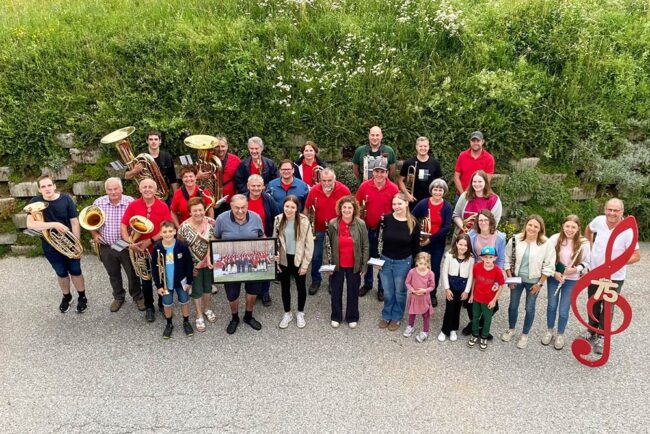 75erFaltinFranz-Gruppe Eine Gruppe Menschen mit Instrumenten und dem Jubilar in der Mitte.