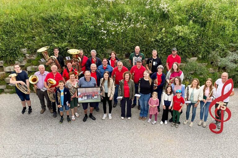 Eine Gruppe Menschen mit Instrumenten und dem Jubilar in der Mitte.