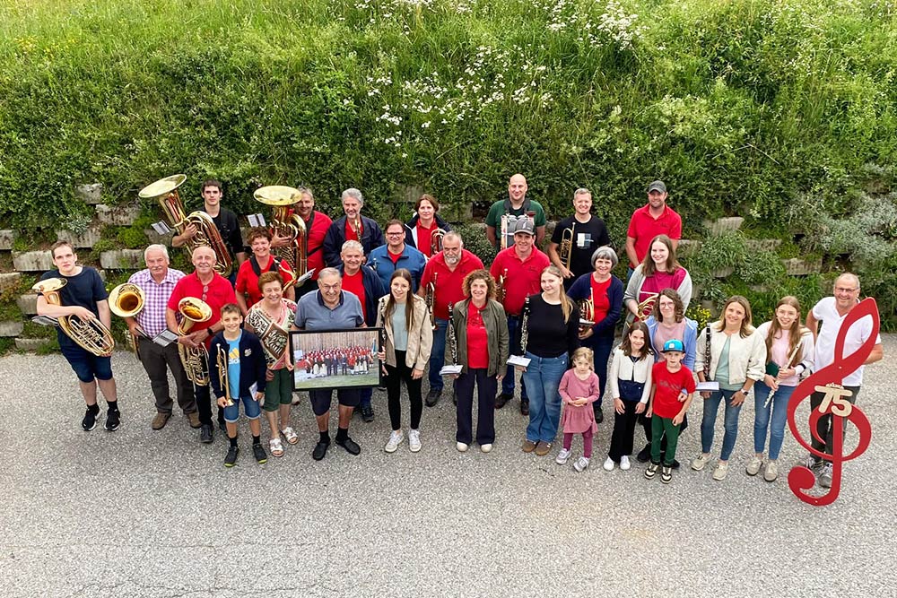 Eine Gruppe Menschen mit Instrumenten und dem Jubilar in der Mitte.