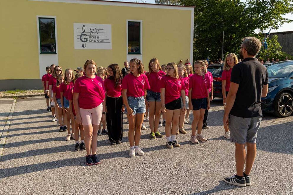 Eine Gruppe junger Menschen stehe in 5er Reihen hinter dem Stabführer